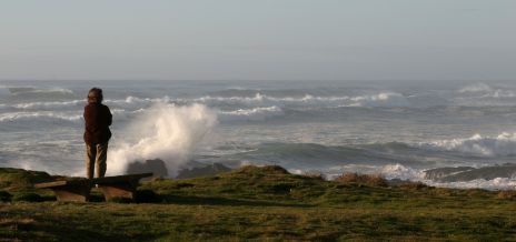 Woman Watching Waves Crashing on Rocks, OR 